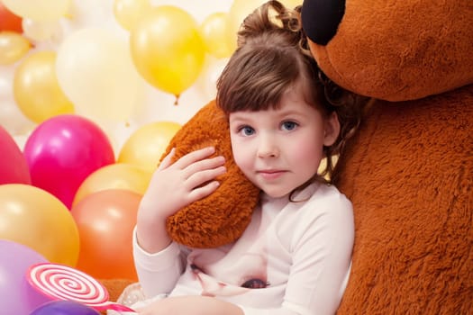 Portrait of lovely little girl hugging teddy bear, close-up