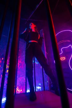 Caucasian woman in neon studio behind steel bars