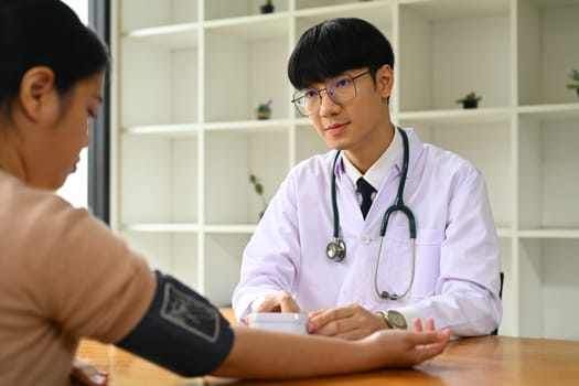 Doctor giving recommendations and measuring blood pressure female patient. Medical and health care concept.