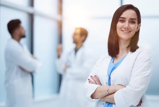 Confident female doctor posing in her office and smiling at camera, health care and prevention concept