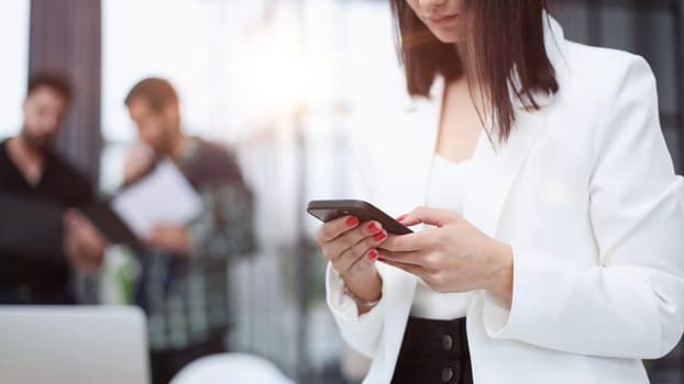 Modern gadget. Close-up of a smartphone screen in the hands of a business woman.