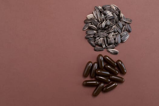 Flatly Sunflower Lecithin Softgel Pill Capsule And Sunflower Seeds On Brown Background. Vitamin, Dietary Supplements. Copy Space For Text. Healthy Lifestyle. Horizontal Plane. High quality photo