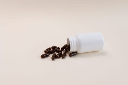 Lying White Bottle, Container With Scattered Brown Sunflower Lecithin Softgel Pill Capsules On Beige Background. Vitamin, Dietary Supplements. Copy Space For Text. Healthy Lifestyle. Horizontal Plane.