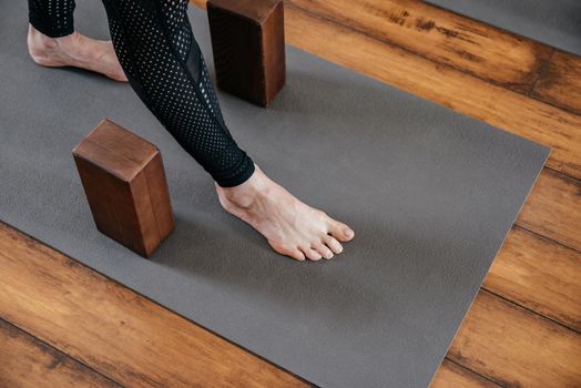 Cropped view of woman stretching her leg with rope during yoga class