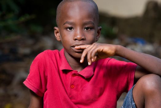 close-up of little boy sitting alone with his hand on his mouth and reflection