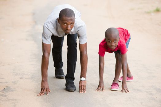 happy family, father and son compete near the start, having fun running together on a road