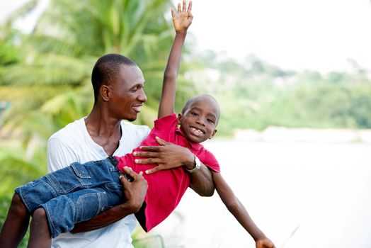 Portrait of father with his son having fun in the park. Family fun happy boy playing with dad outdoors in nature