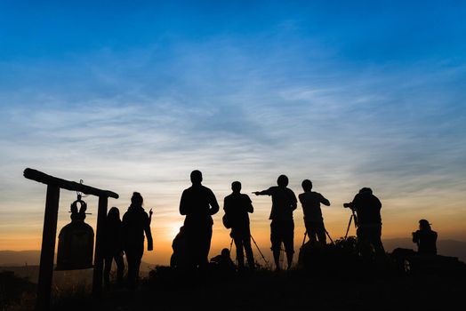 Photographers Silhouettes On Cliff Against Colorful Twilight Sky