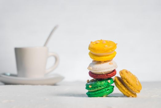 colourful french macaroons with cup of coffee on white background