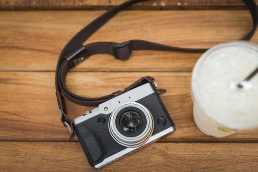 vintage camera with ice coffee on wooden table