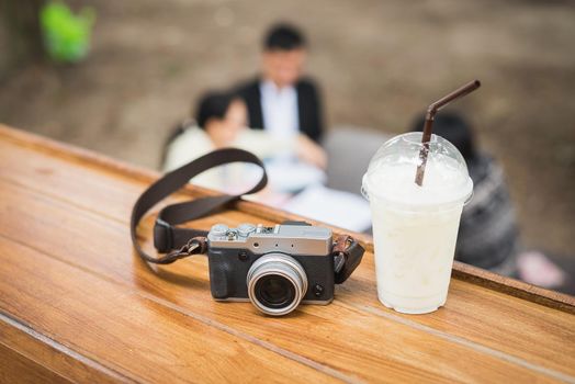 vintage camera with ice coffee on wooden table