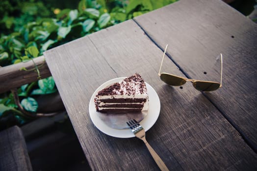 Delicious chocolate cake with glasses on table