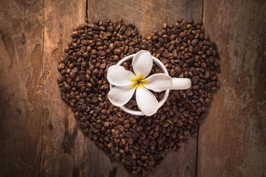 coffee cup and coffee bean on wooden table