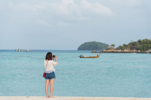 asia girl take photo on the beach