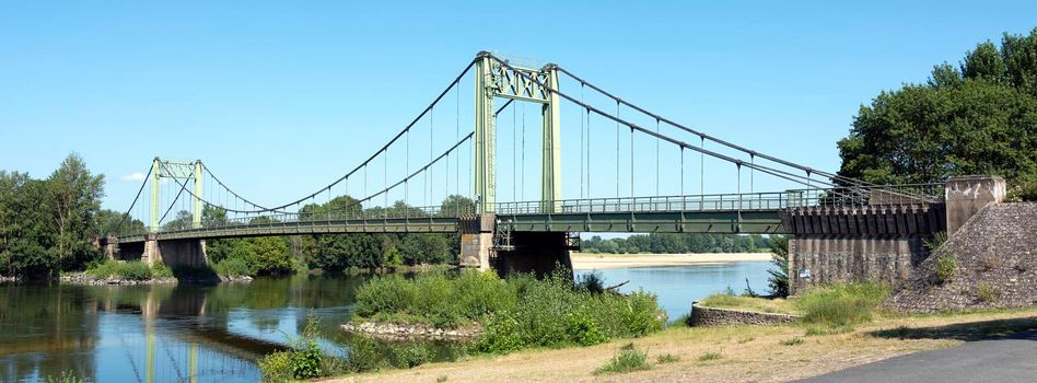 bridge over river loire in france between angers and tours under blue summer sky