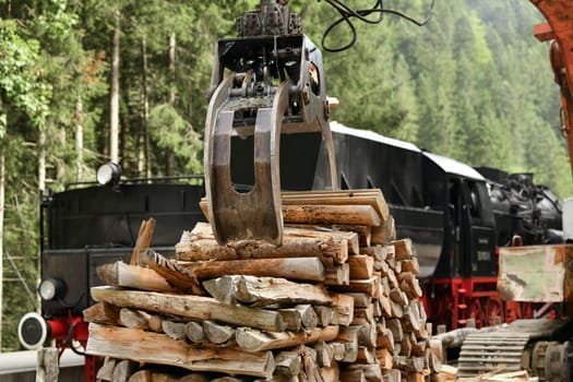Scrap locomotive loading firewood into a vintage steam locomotive