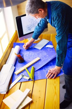 Architect working on drawing table in office.