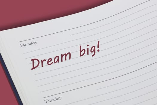 A Dream big reminder note in red ink in a diary page