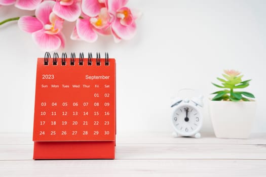 Red calendar September 2023. Desk calendar for year 2023 and pink color orchid.