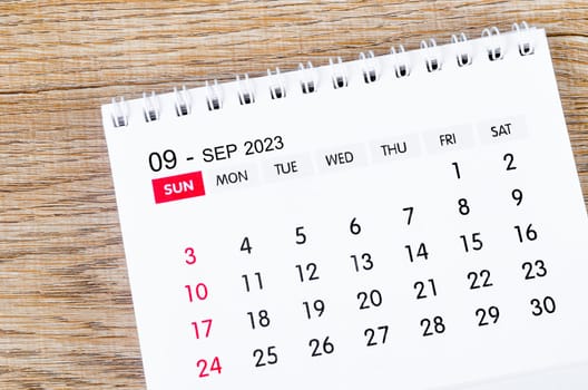 September 2023 desk calendar for 2023 on wooden background.