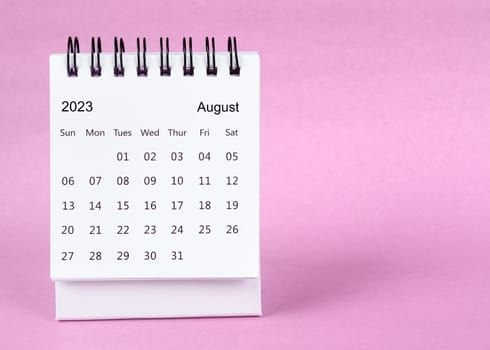 August 2023 desk calendar on pink color background.