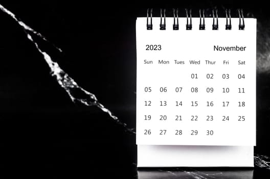 November 2023 Monthly desk calendar for 2023 year on black marble background.