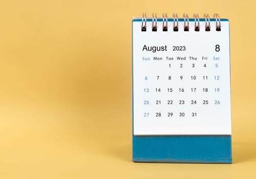 August 2023 desk calendar on yellow color background.