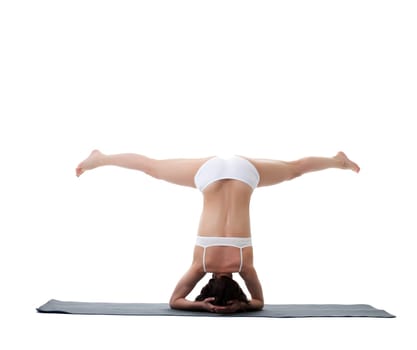 Rear view of young athletic woman doing handstand