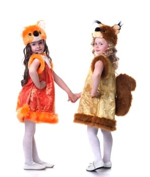 Cute young friends posing in carnival costumes, isolated on white