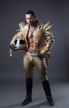 Studio shot of hot muscular man posing in golden costume
