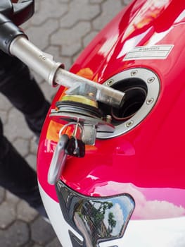 Cremona, Italy - July 3 2023 Customer self service refilling motorbikes at eni gas station