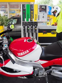 Cremona, Italy - July 3 2023 Customer self service refilling motorbikes at eni gas station