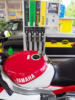 Cremona, Italy - July 3 2023 Customer self service refilling motorbikes at eni gas station