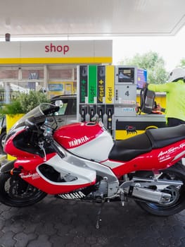 Cremona, Italy - July 3 2023 Customer self service refilling motorbikes at eni gas station
