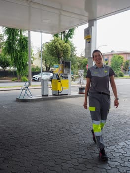 Cremona, Italy - July 3 2023 smiling female staff at Eni Agip italian gas station working outdoors