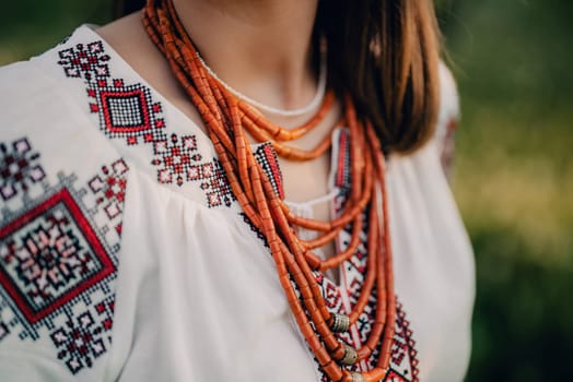 Ukrainian woman in embroidery vyshyvanka dress and ancient coral beads. Traditional antique jewelry necklace and costume of Ukraine.