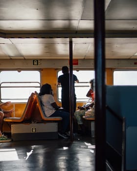 Unrecognisable multicultural travellers in Lisbon ferry which cross the Tagus river.