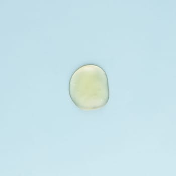 Drop of transparent face and body cream on a blue background