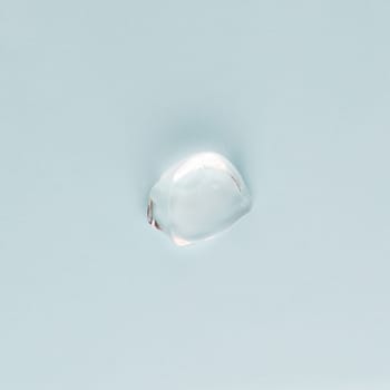 Drop of transparent face and body cream on a blue background