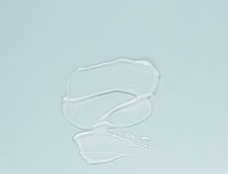 Smear of transparent cream for face and body on a blue background