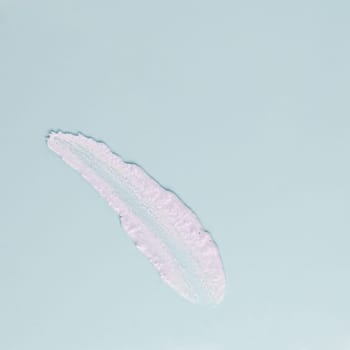 Smear of white cream for face and body on a blue background