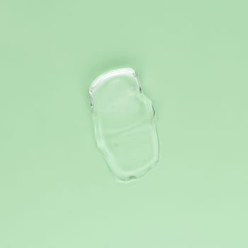 Smear of transparent cream for face and body on a green background