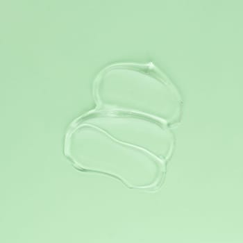 Smear of transparent cream for face and body on a green background