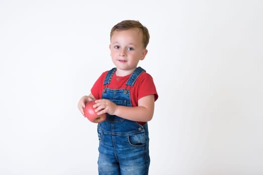 portrait of a girl eating red apple isolated on white. Healthy nutrition. free space.