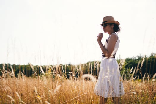 Portrait of woman in golden sunset light in outdoor meadow. Springtime and summer lifestyle. Wellbeing and zen like meditation activity in outdoor. Loving life