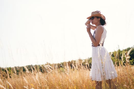 Portrait of woman in golden sunset light in outdoor meadow. Springtime and summer lifestyle. Wellbeing and zen like meditation activity in outdoor. Loving life