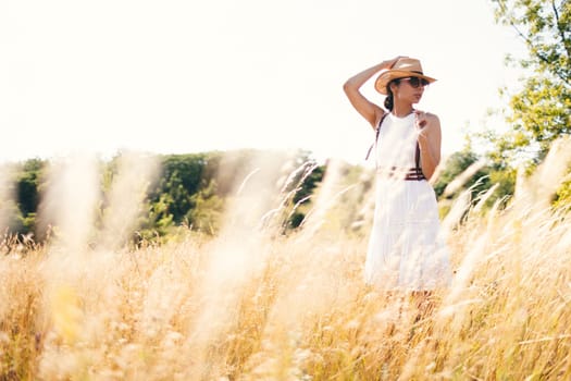 Beautiful girl in a linen dress in a wheat field. Summer vacation, traveling. Bohemian, modern hippie style.