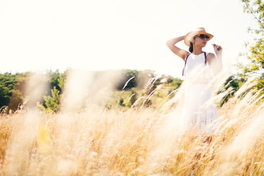 Portrait of woman in golden sunset light in outdoor meadow. Springtime and summer lifestyle. Wellbeing and zen like meditation activity in outdoor. Loving life