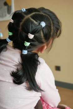 Beautiful ribbon is tied on a child hair .