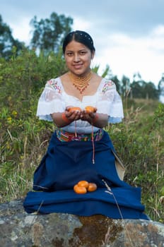 young indigenous man in a Latin American ritual making an offering of some mandarins. High quality photo